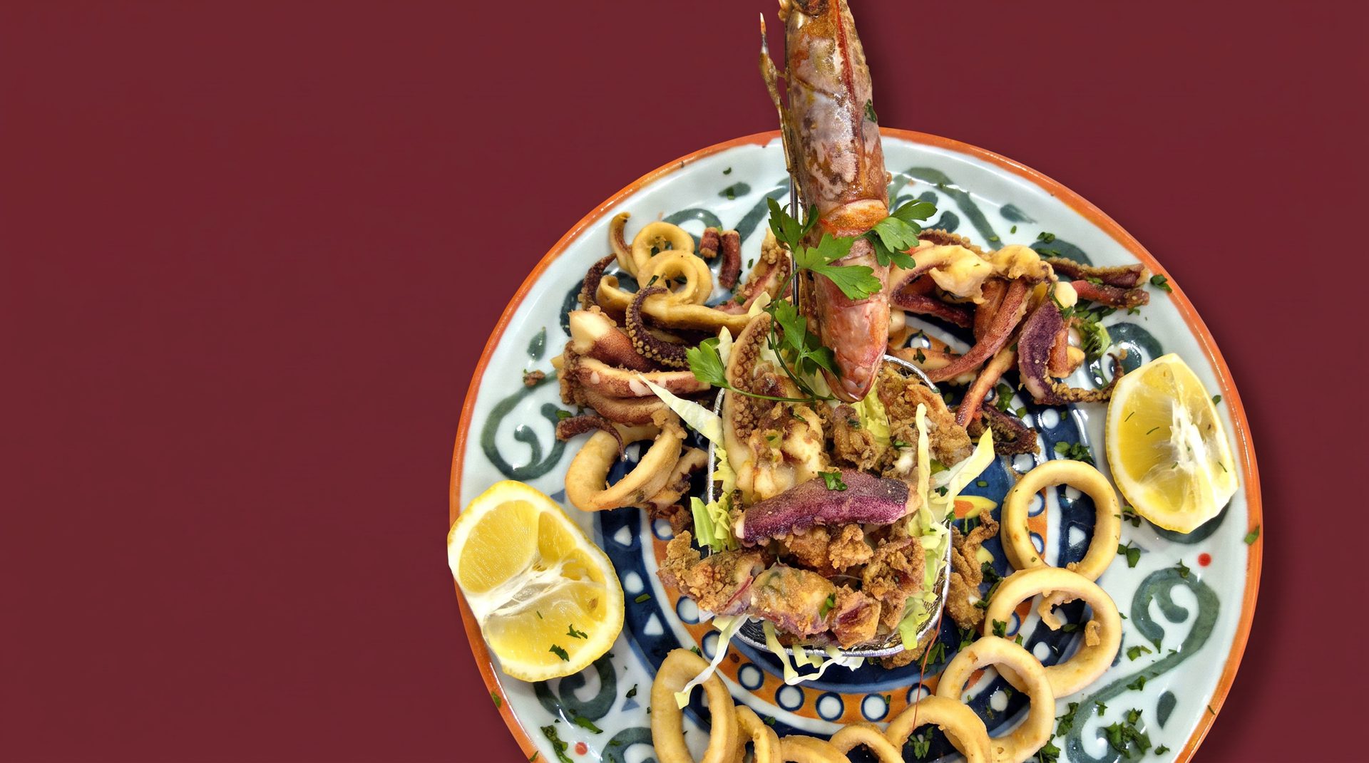 Il mix di pesce fritto della trattoria su un piatto di ceramica dipinta a mano